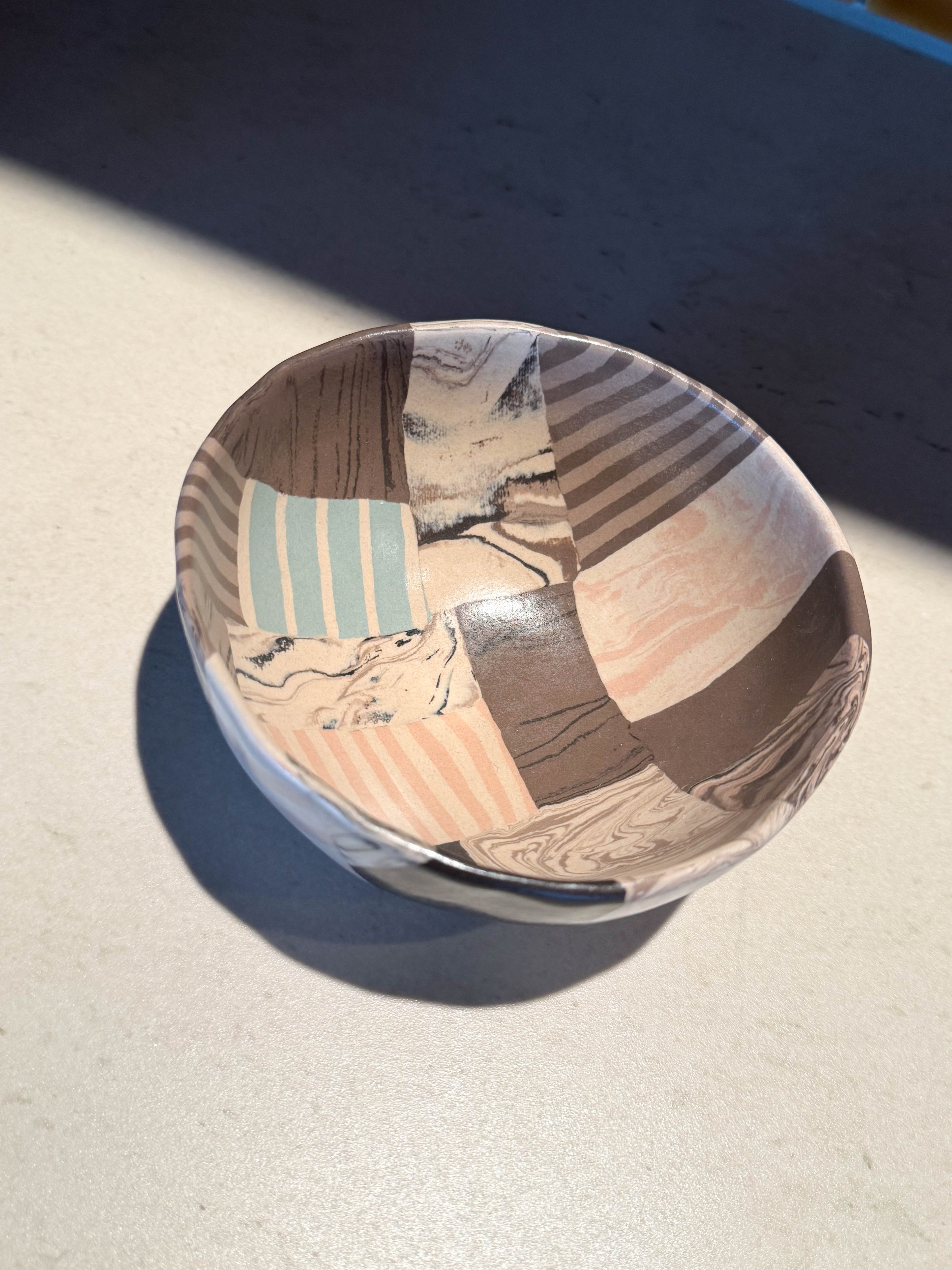 Ceramic bowl with segmented marbled and striped forms