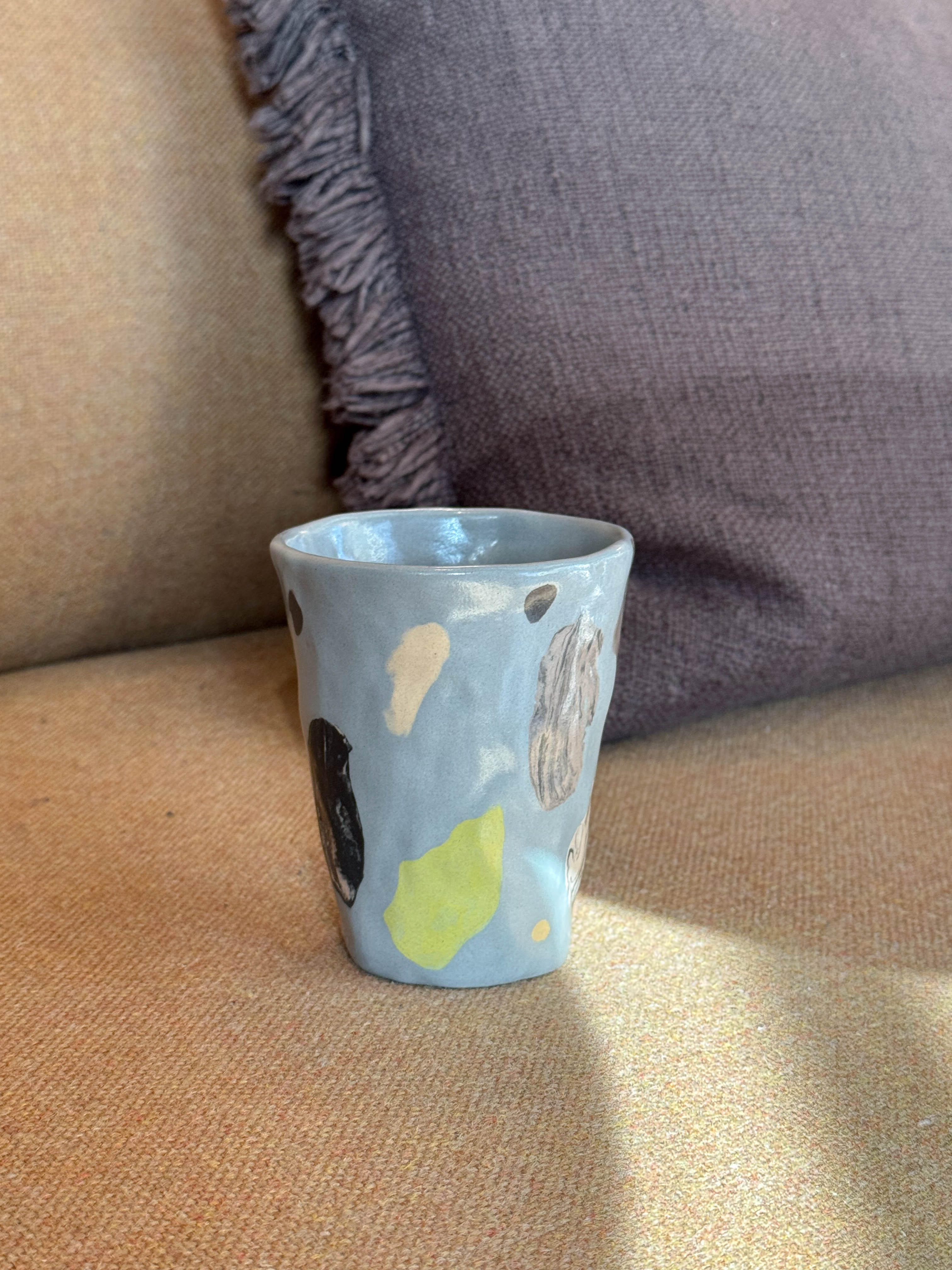 Ceramic cup with painted fragmented forms in a soft blue glaze