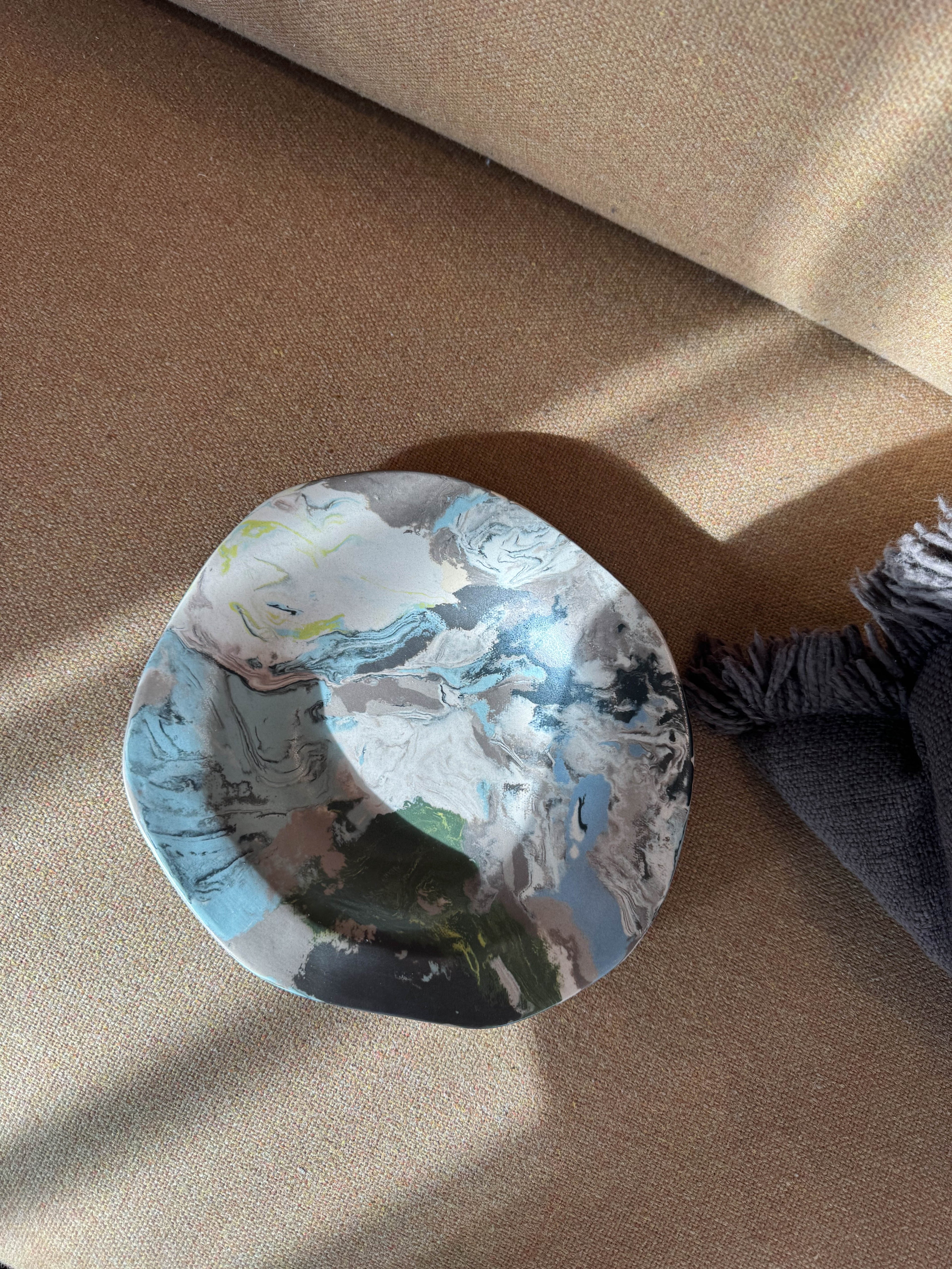 Ceramic plate with contrasting flowing marbled glaze