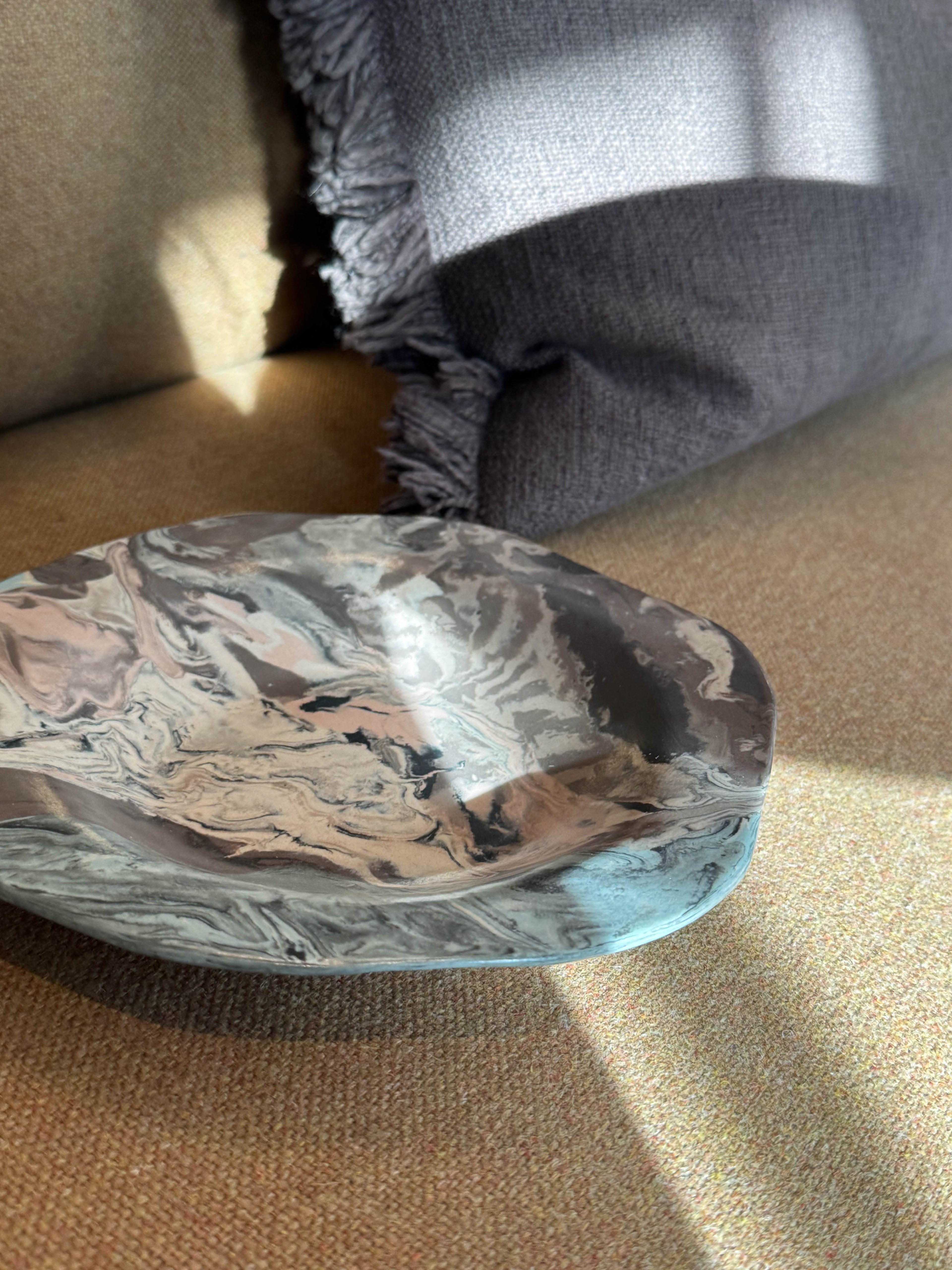 Ceramic plate with dense flowing marbled glaze