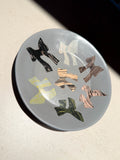Ceramic plate with painted ribbon forms in a soft grey glaze