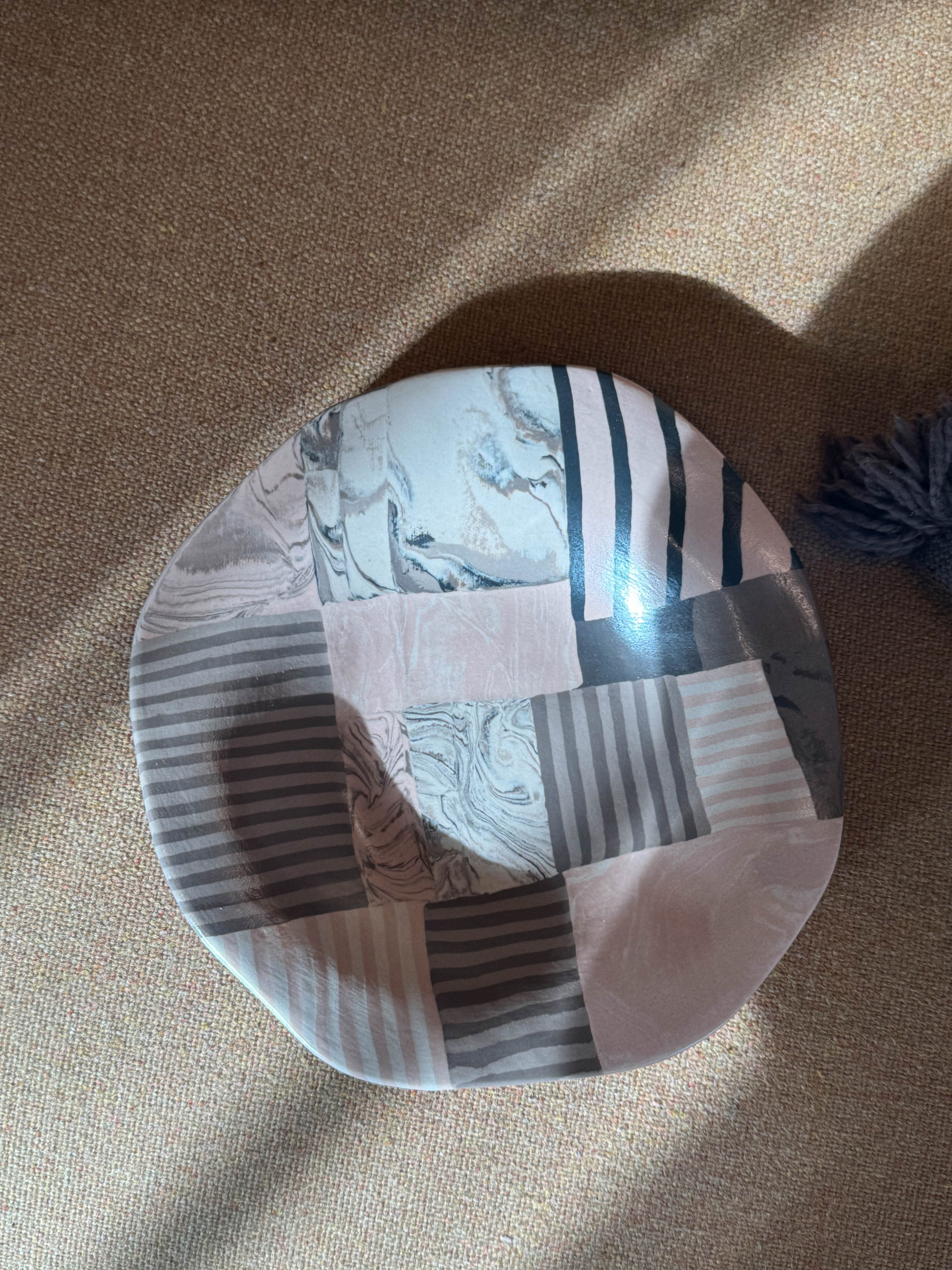 Handmade ceramic plate with layered striped and marbled forms